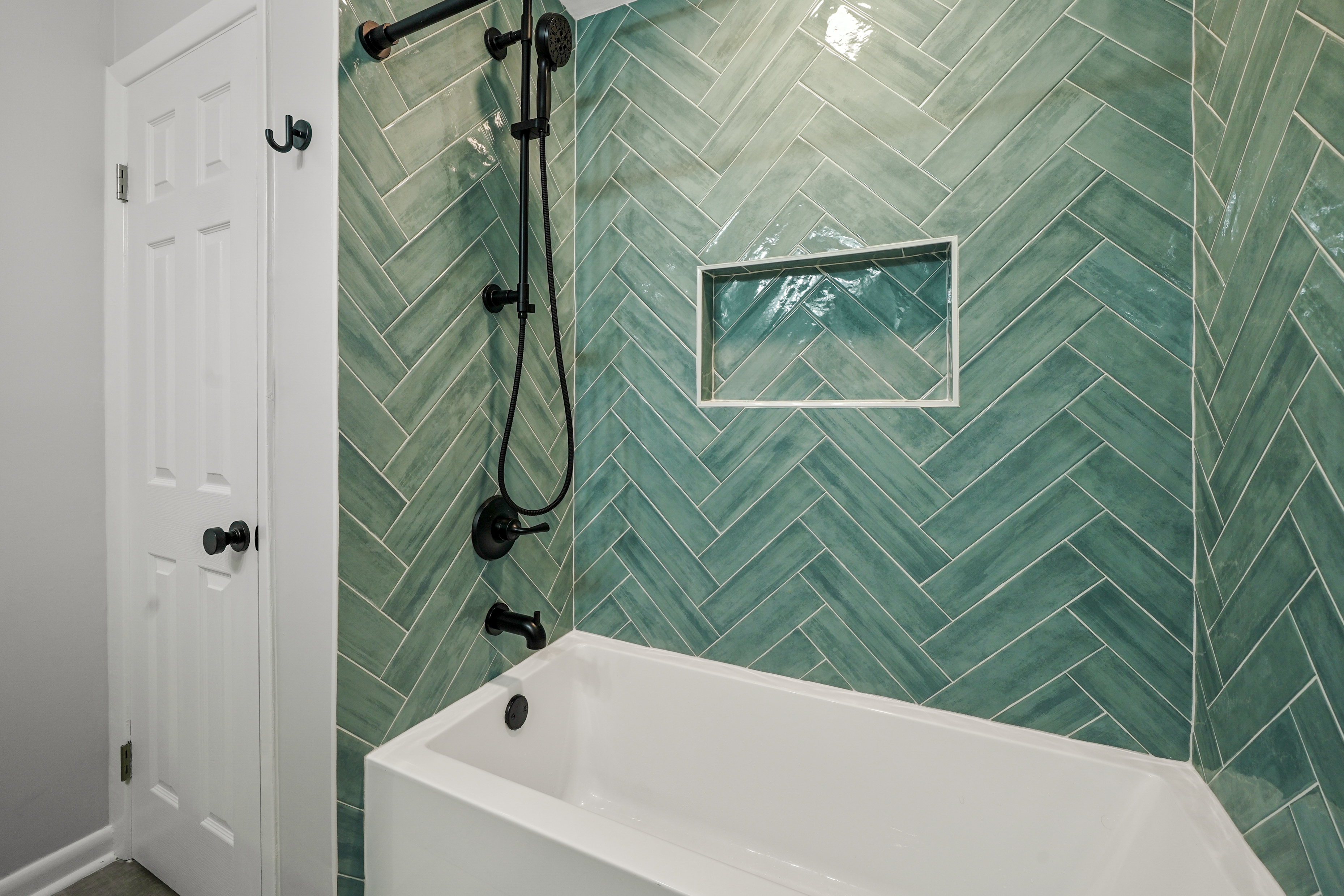 Green herringbone tile shower